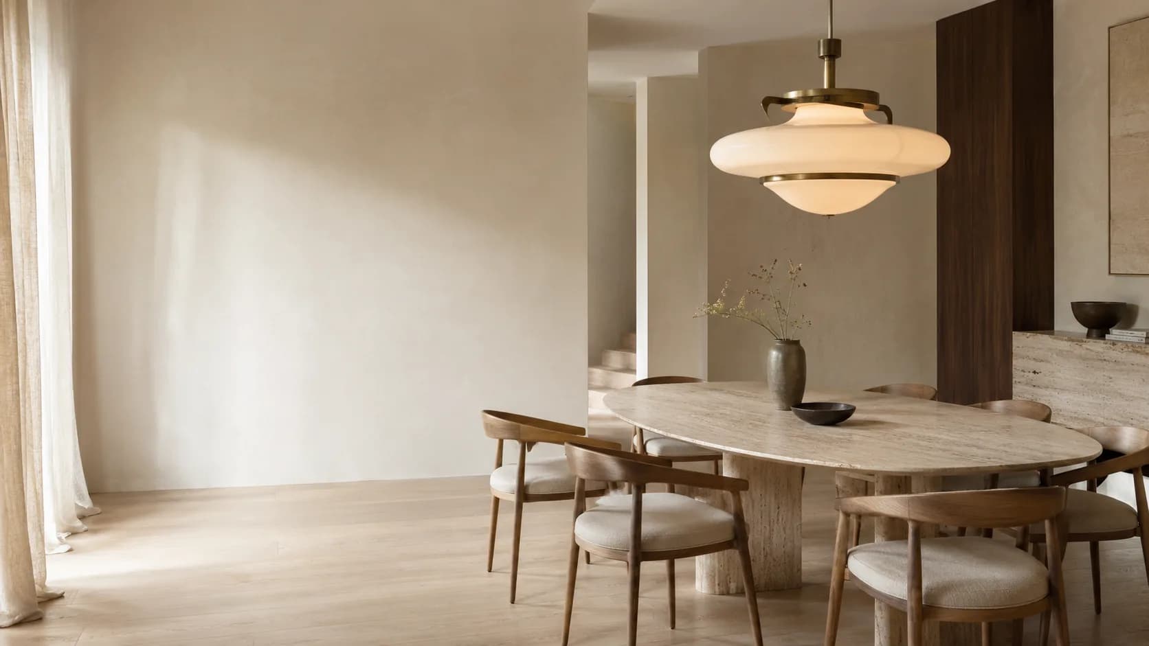Séjour contemporain aux murs crème éclairé par une grande suspension en verre